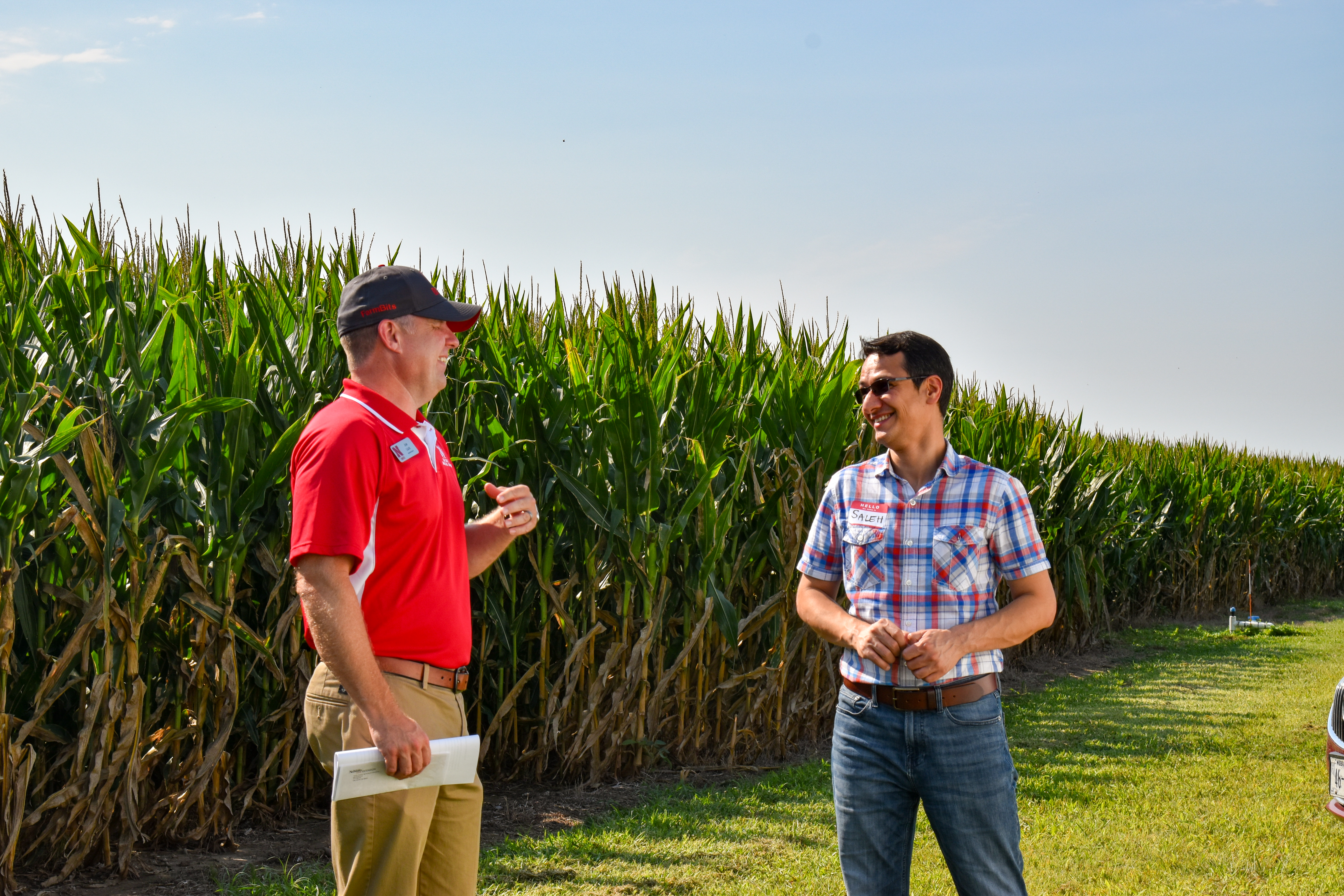 Researchers talking in front of corn field 